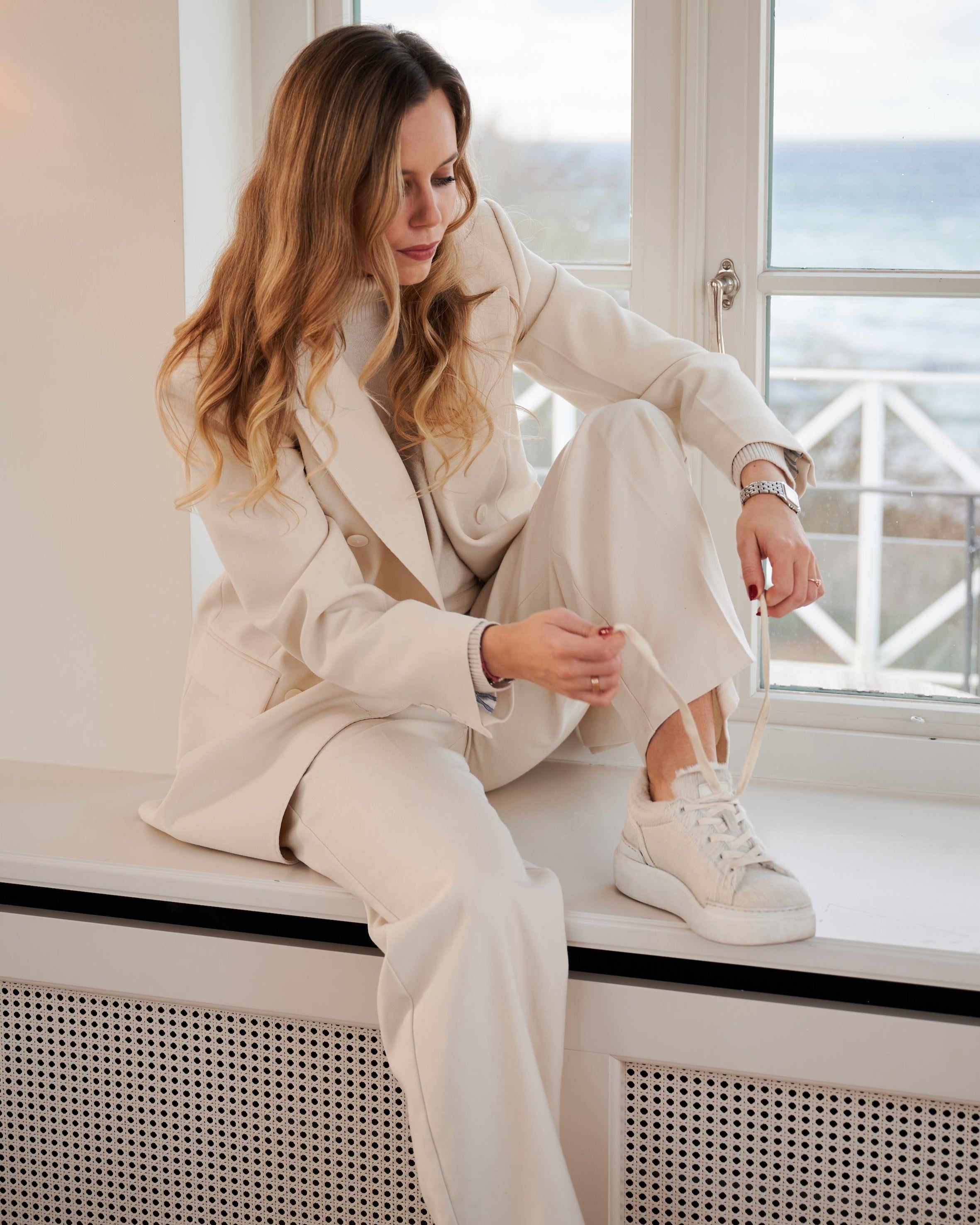 Emilie Cavallino Sneaker Creme – getragen vom Model - kombiniert mit elegantem Look