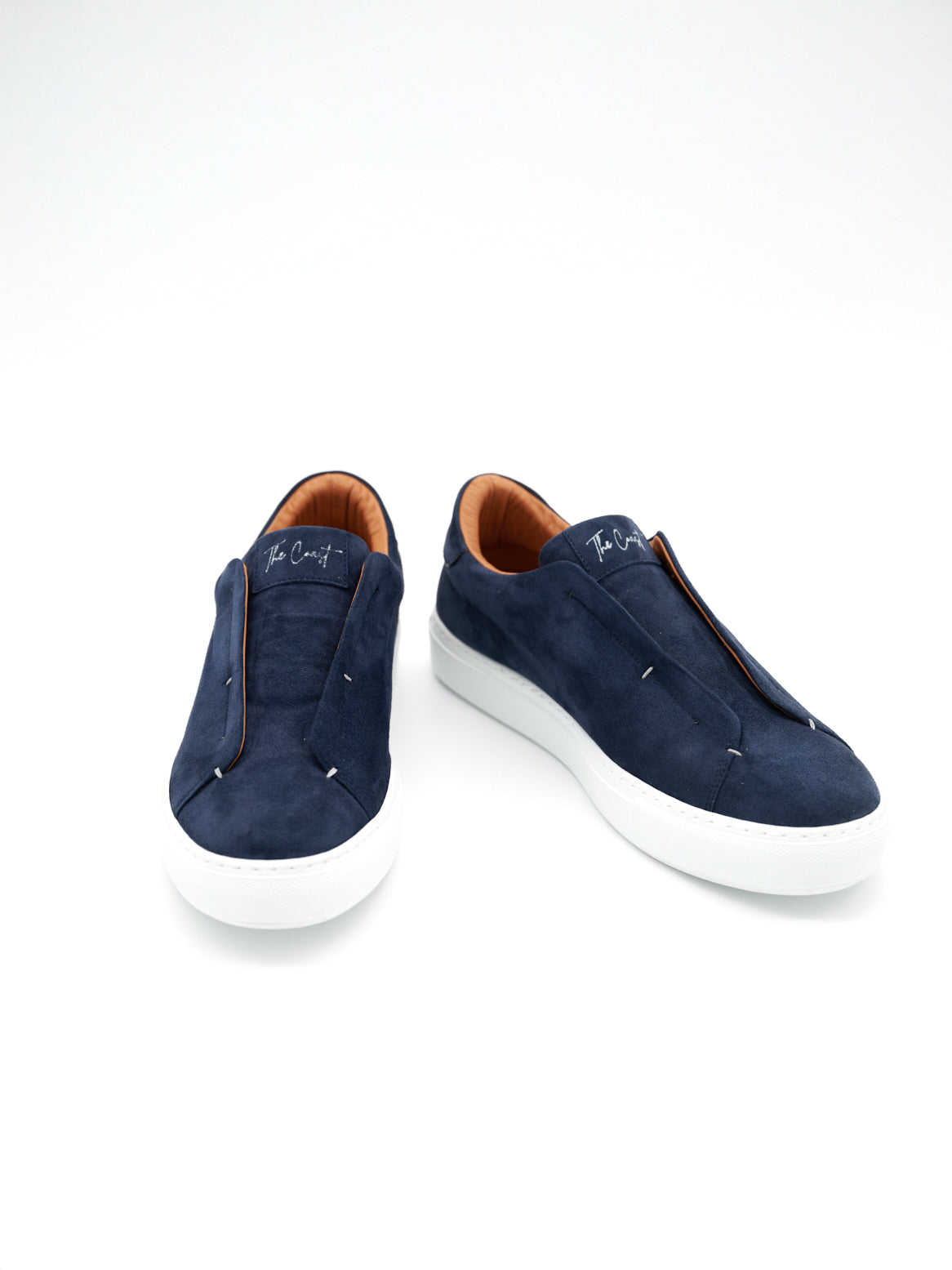 Paaransicht von oben, navyblaue Sneaker auf weißem Hintergrund