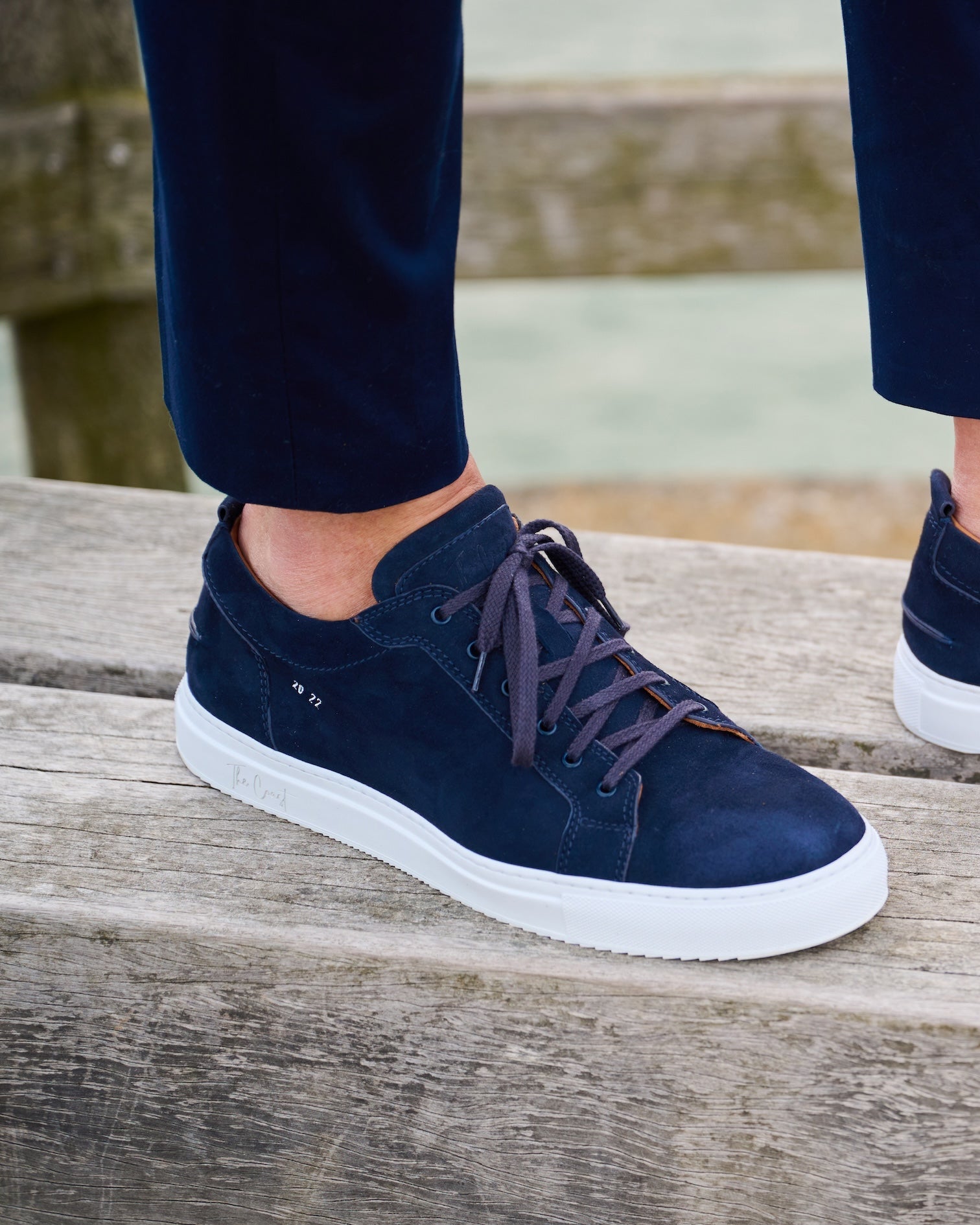 Maxi Sneaker Navy Blau – am Fuß auf Holzgeländer
